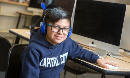 Middle school student at computer with headphones