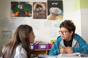 Two students reviewing a textbook together