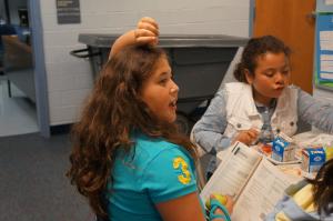 a girl holding a book and raising her hand