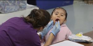 an adult looking inside a child's mouth