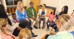 Adults and children sitting in a circle