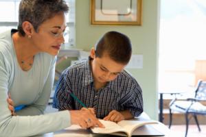 woman working with boy on writing