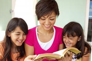 A woman reading with two children.