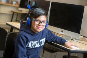 Middle school student at computer with headphones