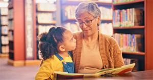 Girl reading with grandmother in the library