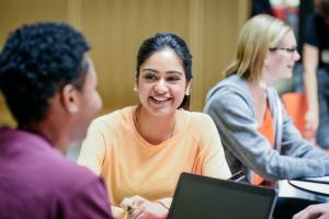 a woman smiling at another adult