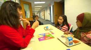 two girls eating while talking to a woman