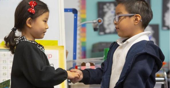 Student shaking hands with another student